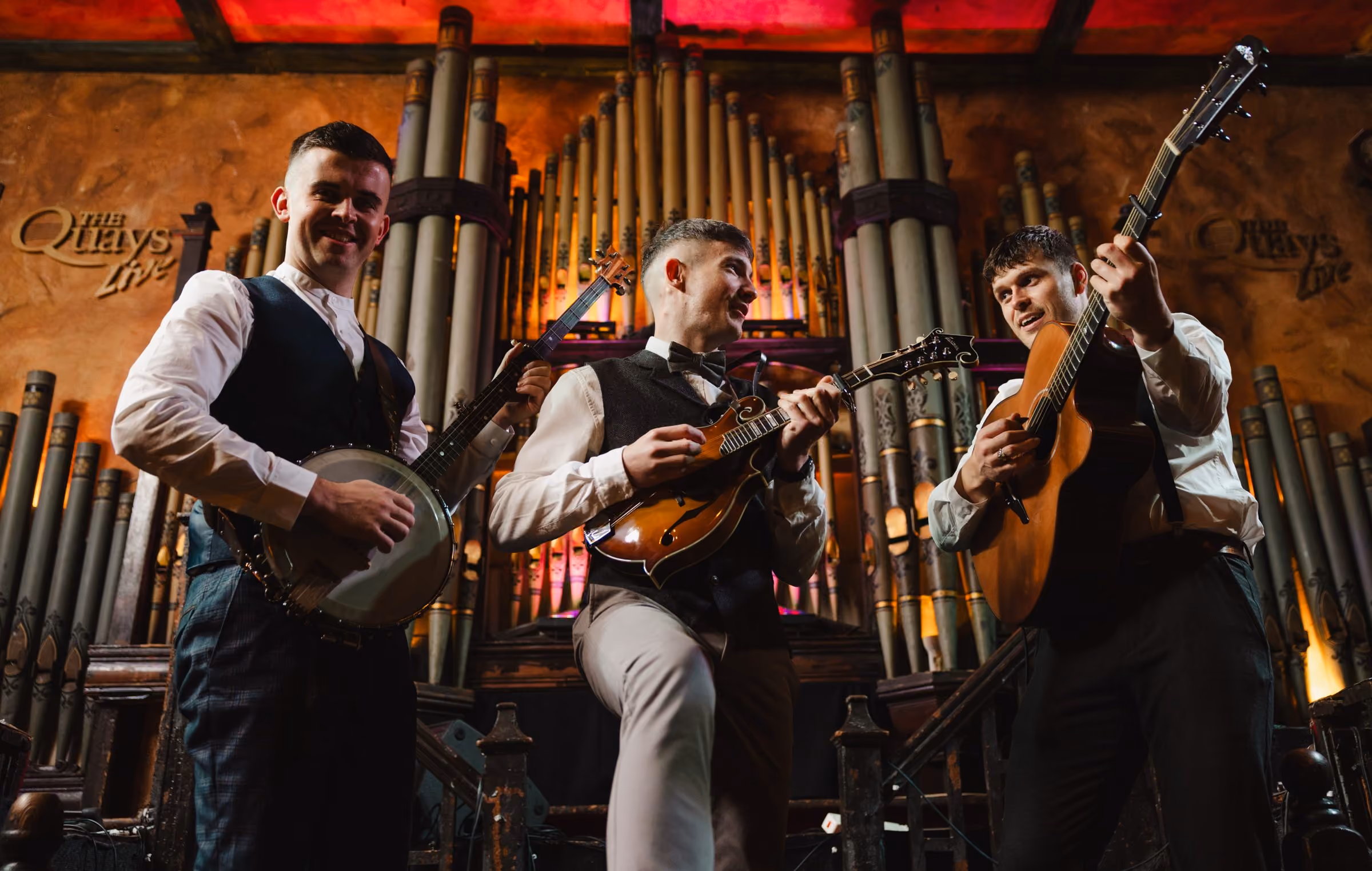 Liam, Thomas and Mark of The Kings of Connaught playing banjo, mandolin and guitar on stage at The Quays, Galway